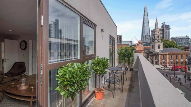 Ein Balkon mit Blick auf The Shard, ein modernes Gebäude, und einen traditionellen Glockenturm.
