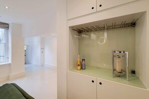 Ein modernes Zimmer mit Glastisch, Weinflaschen und Kerzenhalter.