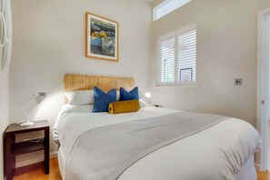 A bedroom with a bed, bedside table, lamp, and a window with blinds. - VY6 - Stylish Loft-Style 1-Bed Near Borough Market (Greater London)