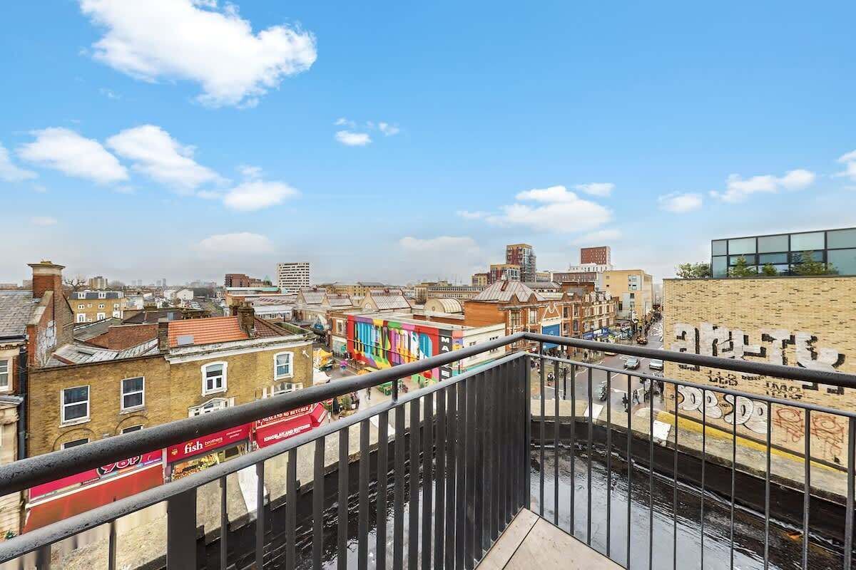 Stadsgezicht met gebouwen, een rivier en een moderne constructie met een glazen gevel.