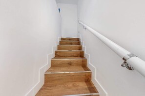 Eine Treppe mit Holzboden und weißen Wänden.