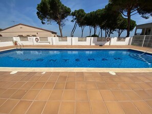 En indendørs swimmingpool med flisegulv og et område ved poolen.