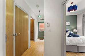 A bedroom with a bed, a bedside table, a lamp, and a window with curtains. - Comfortable 1 BDR Flat in Winchester (Winchester)