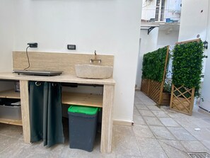 A kitchen area with a countertop, sink, and storage cabinets. - Apartment 'Touristhouse Monopoli 10' with Balcony, Wi-Fi and Air Conditioning (Monopoli)
