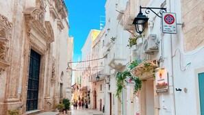 A narrow street with historic buildings, a sign for a restaurant, and a no parking sign. - Apartment 'Touristhouse Monopoli 10' with Balcony, Wi-Fi and Air Conditioning (Monopoli)