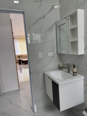 A modern bathroom with a white vanity, a mirror, and a sink. -    35 Min POP Airport Modern Oasis Near Beach (Villa Progreso)