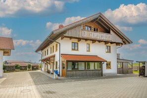 A two-story building with a balcony, a garage, and a paved driveway. - Apartment 'Für 3 Personen 47 M²' with Sea View, Balcony and Wi-Fi (Egling)