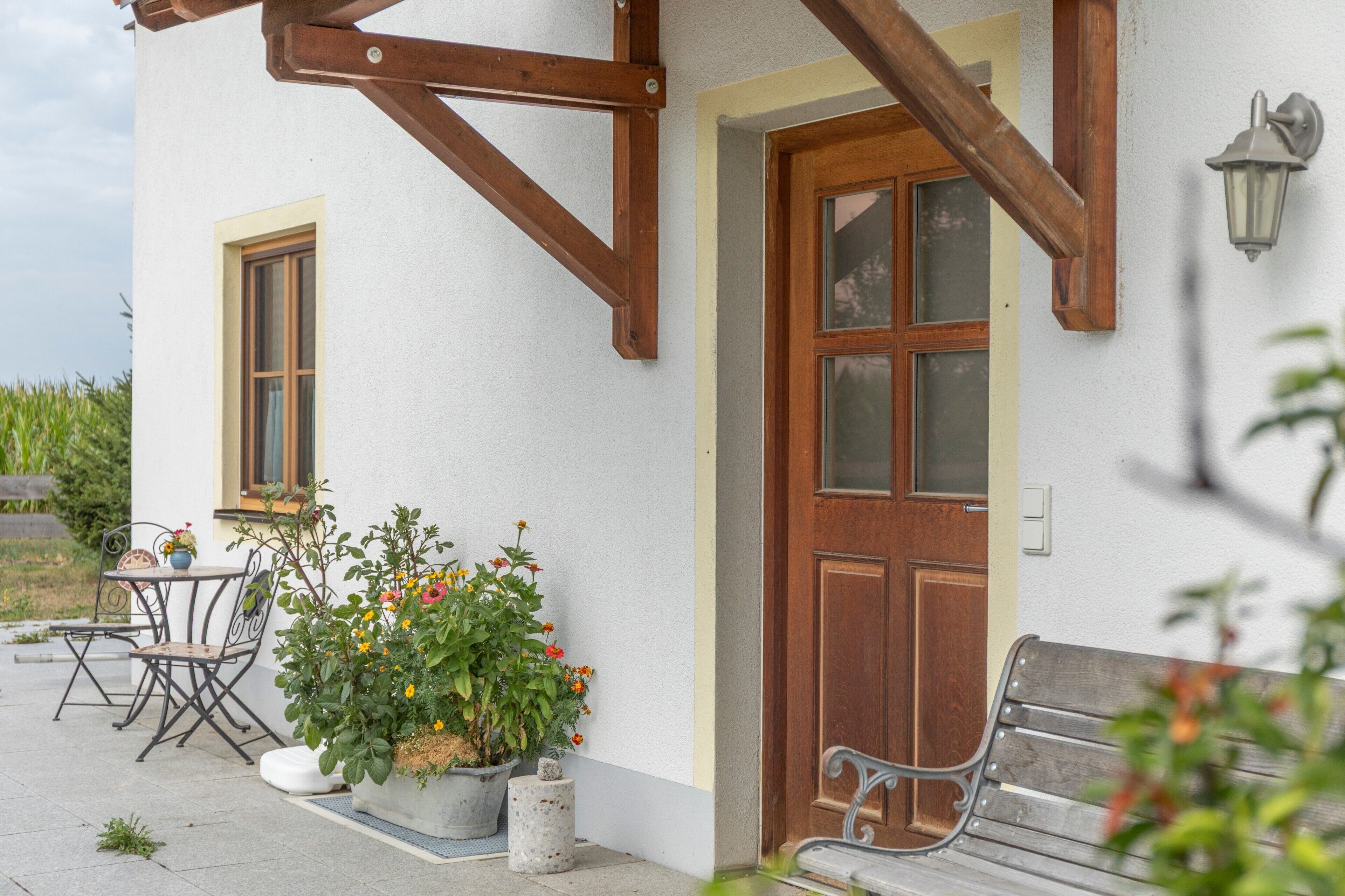 A building with a wooden door, a window, and a bench outside.