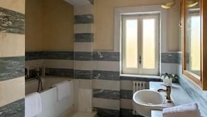 A bathroom with a checkered floor, a bathtub, a sink, and a window.