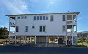 Un bâtiment à deux étages, doté d’un balcon à l’étage supérieur, d’un porche avant couvert et d’un garage.