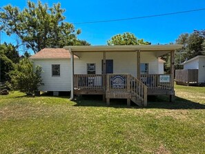 A single-story house with a front porch, a small deck, and a garage. - Ocracoke Local 4: Harbor Views | Private Boat Slip | King Bed (Ocracoke)