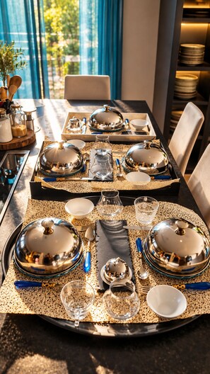 A dining table set with multiple place settings, including plates, bowls, glasses, and cutlery. - Idylle apartment – Sleeps 2, with a large terrace and a view (Pertuis)