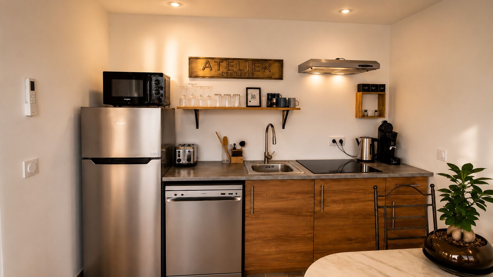 A compact kitchen with a refrigerator, microwave, toaster, sink, and a coffee maker.