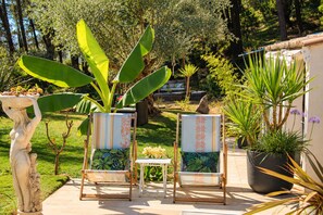 Two chairs with patterned cushions, a small table, and a statue in a garden setting. - Idylle apartment – Sleeps 2, with a large terrace and a view (Pertuis)