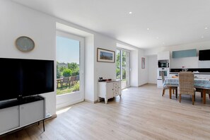 Una cocina moderna con comedor, ventanas amplias y televisor de pantalla plana.