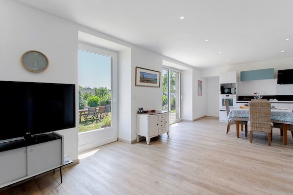 Una cocina moderna con comedor, ventanas amplias y televisor de pantalla plana.