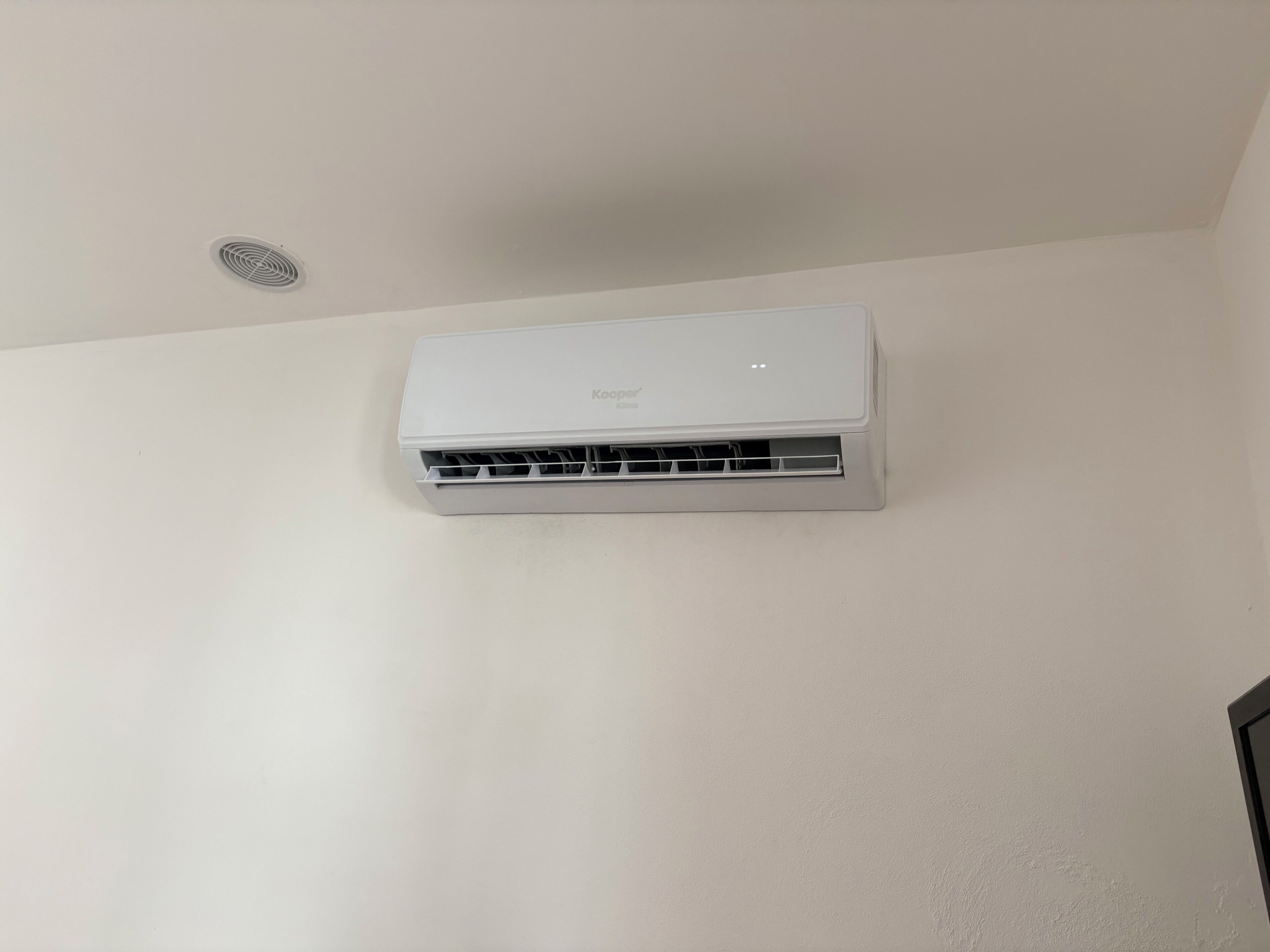 Un aire acondicionado Kooperatier fijado en una pared lisa.