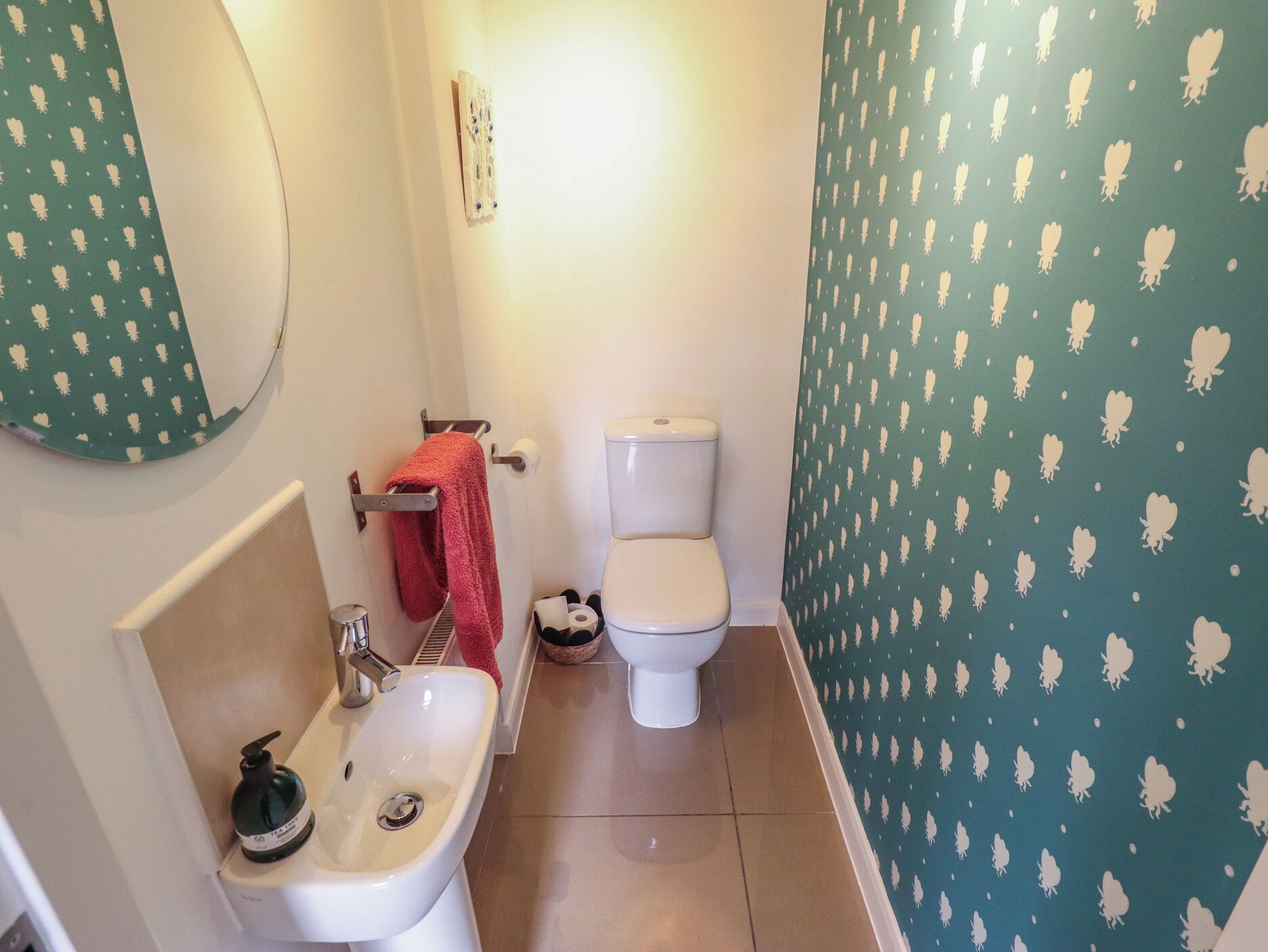 A bathroom with a sink, toilet, and mirror.