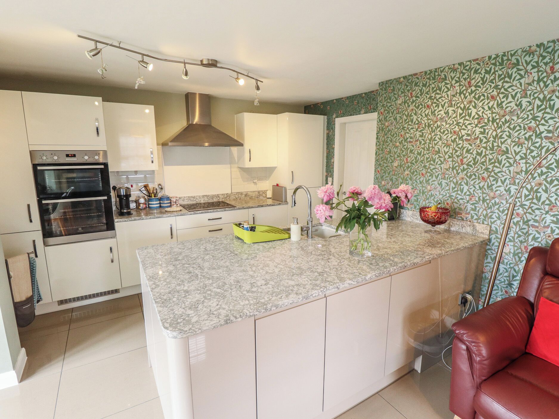 Una cucina moderna con isola centrale, forno integrato e zoccolo decorativo.