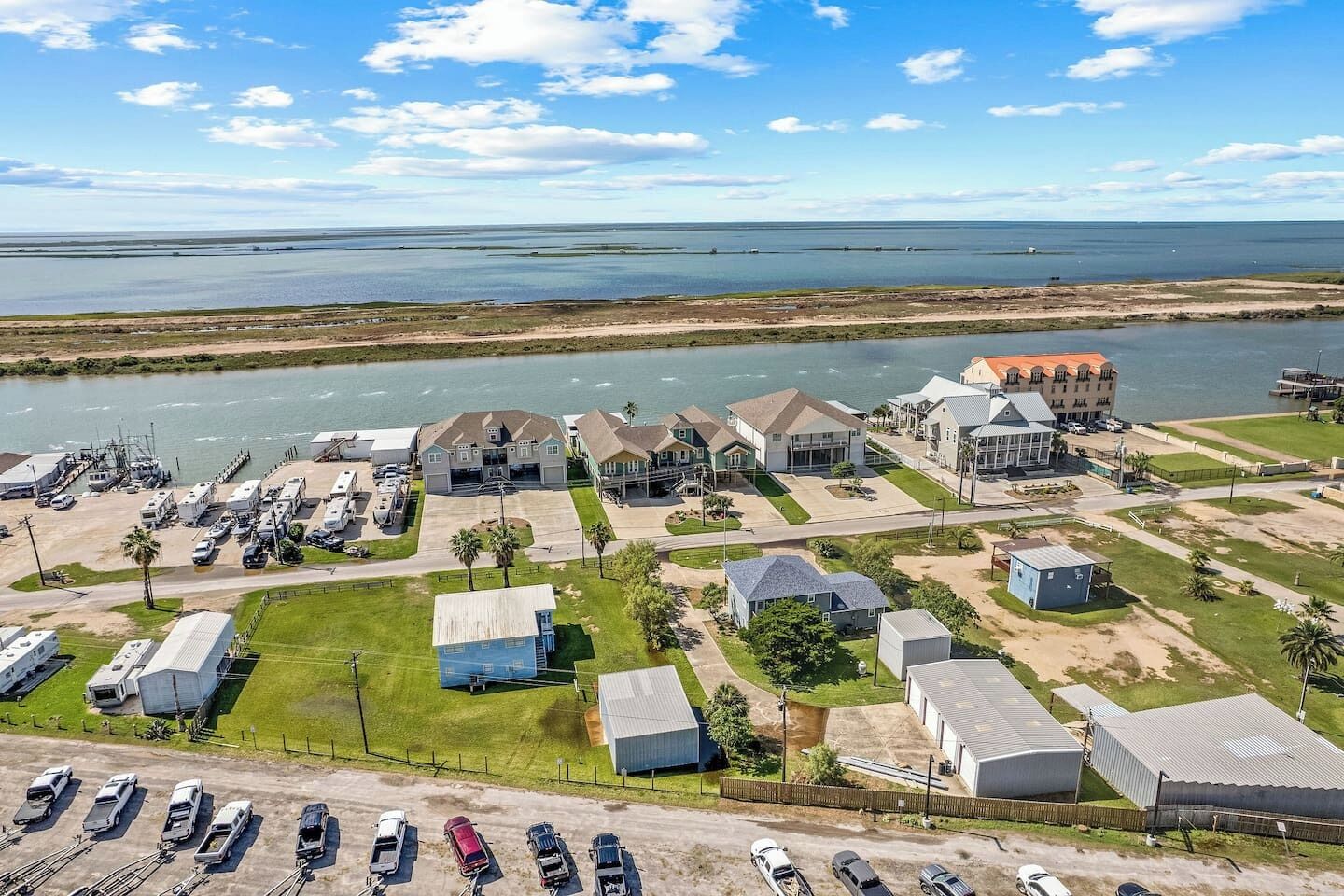 Vista aérea de uma área residencial costeira com casas, trailers e um porto de iates.