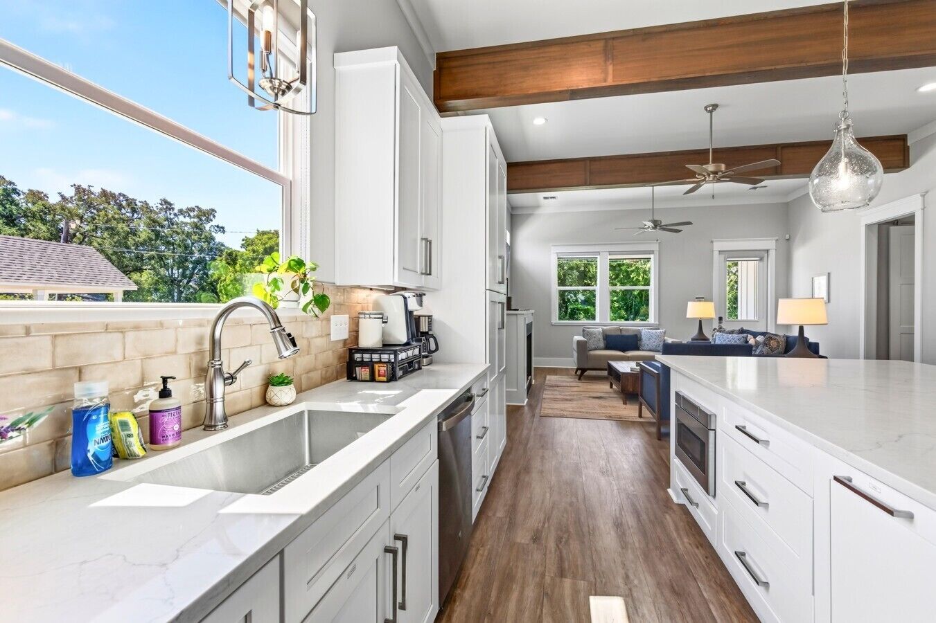 A modern kitchen with a large island, built-in appliances, and a view to the outdoors.