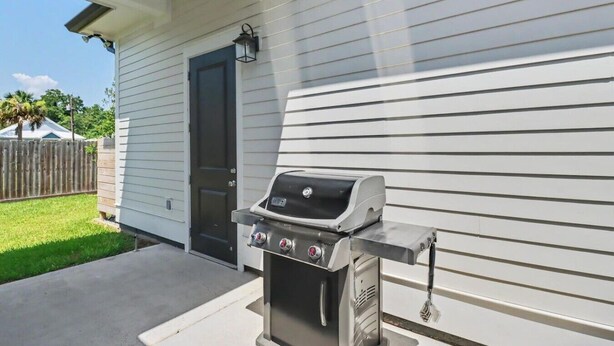 A grill outside a house with a door and a window. - Caron House - Bay St. Louis (Bay St. Louis)