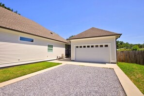 A two-story house with a garage, a covered patio, and a gravel driveway. - Caron House - Bay St. Louis (Bay St. Louis)