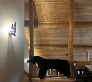 Un interior de madera con techo y una lámpara fijada a la pared.