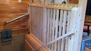 Una escalera de madera con barandilla, una cerca de madera y un letrero que dice 'The sea anchors my soul'.