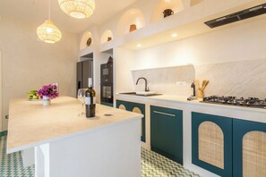 Una cucina moderna con isola centrale, elettrodomestici integrati e pavimento decorato.