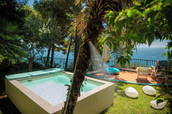 A pool area with a clear view of the sea, surrounded by lush greenery and a lounge area with chairs. - Amalfitana Relais - Private Sea View Villa (Vietri sul Mare)