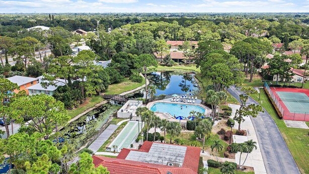 Et boligområde med swimmingpool, tennisbaner og en sø.