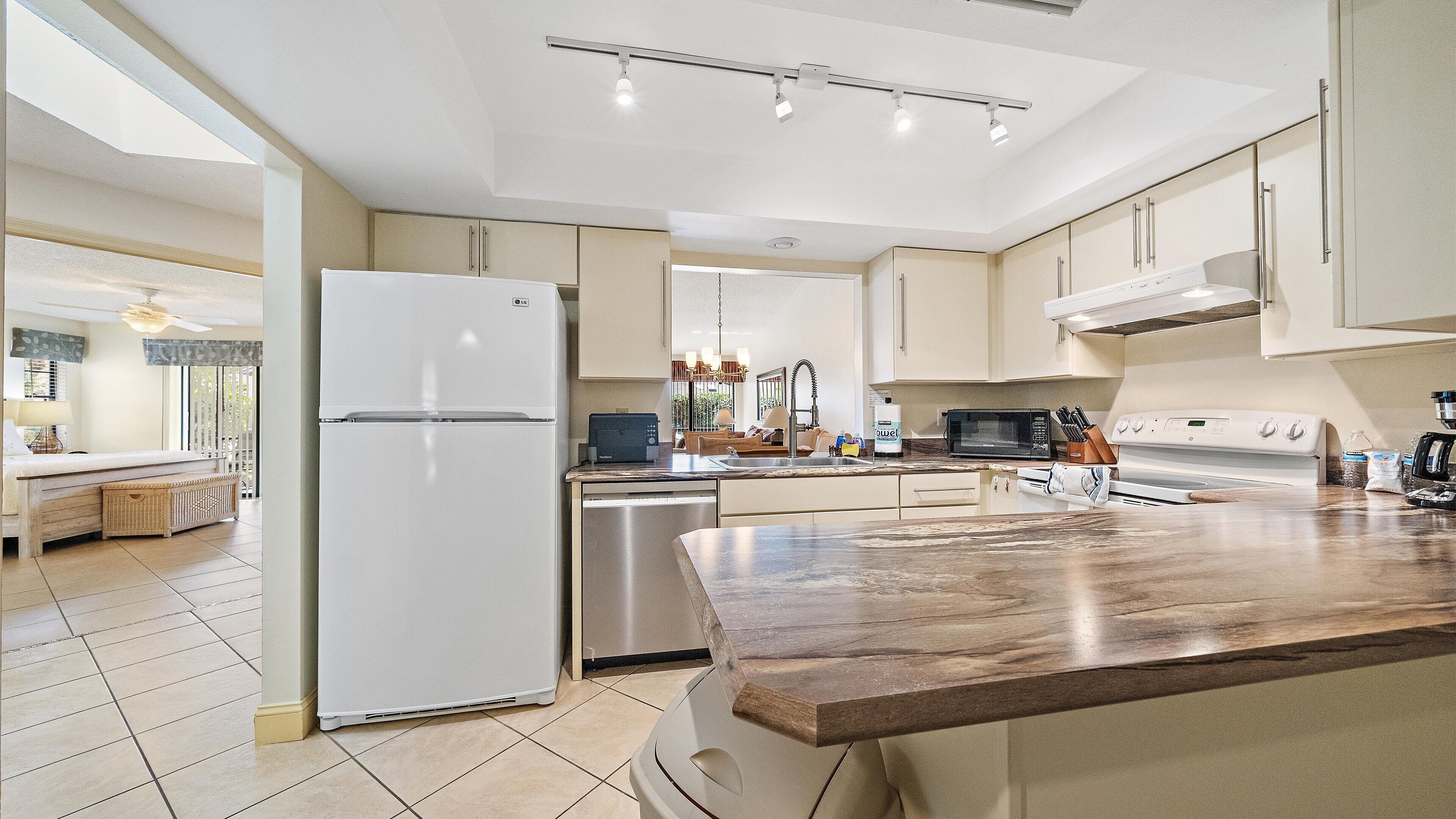 A modern kitchen with a central island, stainless steel appliances, and a view to the dining area.