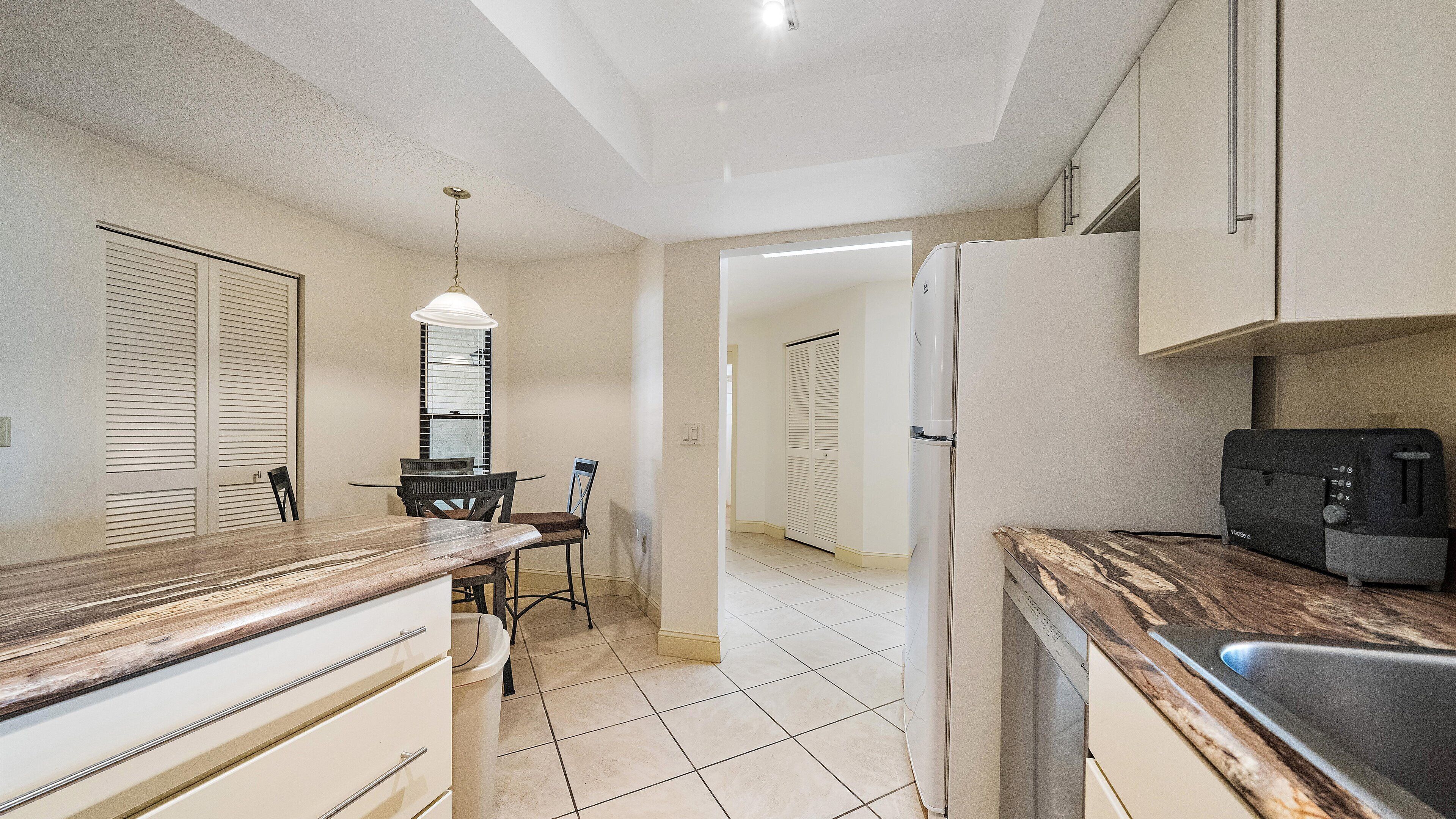 Una cocina con comedor, refrigerador y microondas.