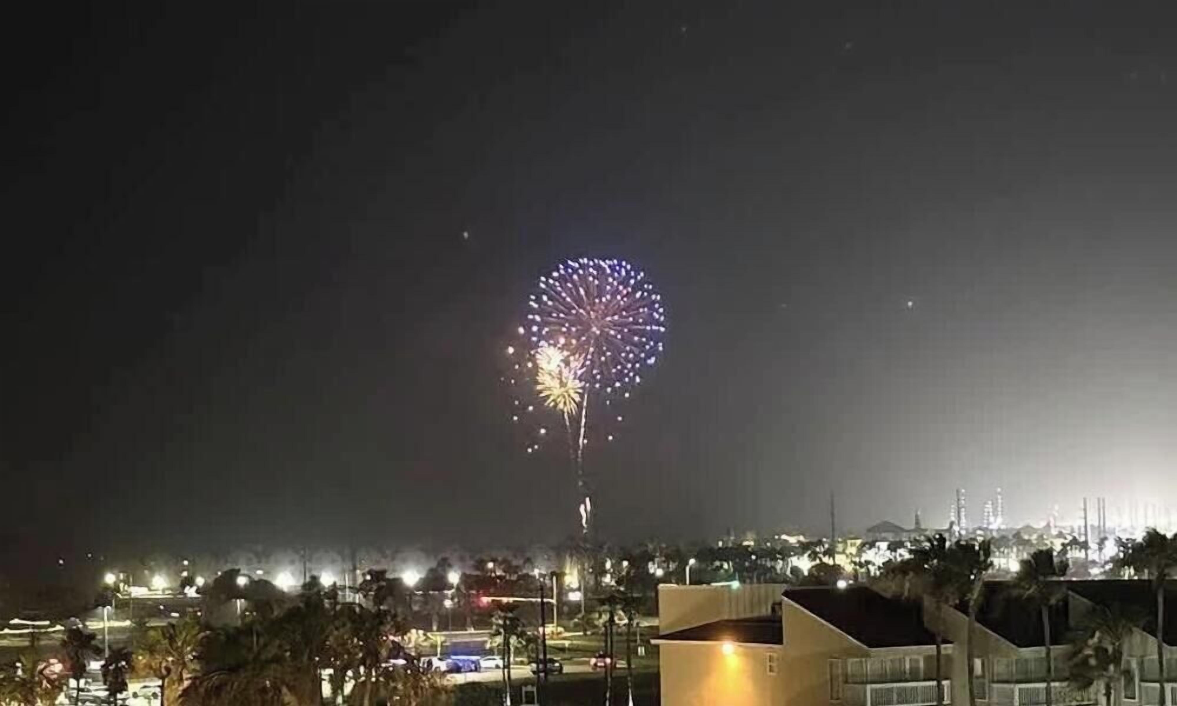 A nighttime view of a cityscape with a prominent display of fireworks.