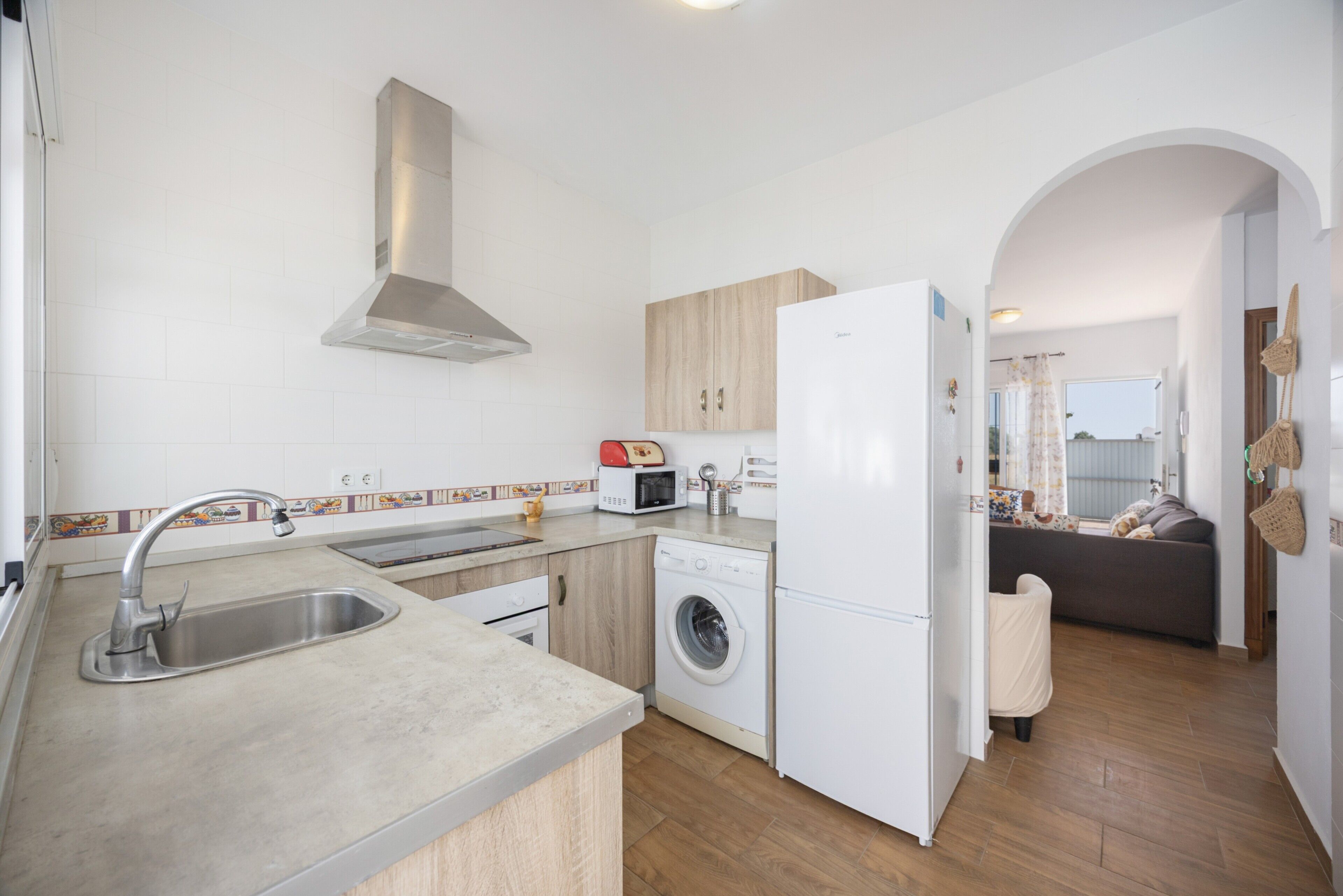 A modern kitchen with a built-in washing machine, a refrigerator, and a microwave.