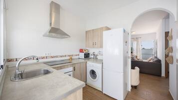 A modern kitchen with a built-in washing machine, a refrigerator, and a microwave.
