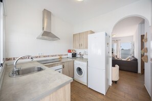 A modern kitchen with a built-in washing machine, a refrigerator, and a microwave.