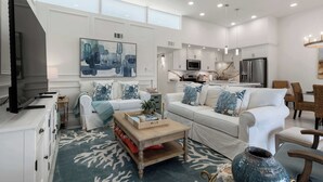 A modern living room with a sofa, coffee table, and a TV. - Isla Bella - 2BR, Cielo del Sol Luxury Condo (South Padre Island)