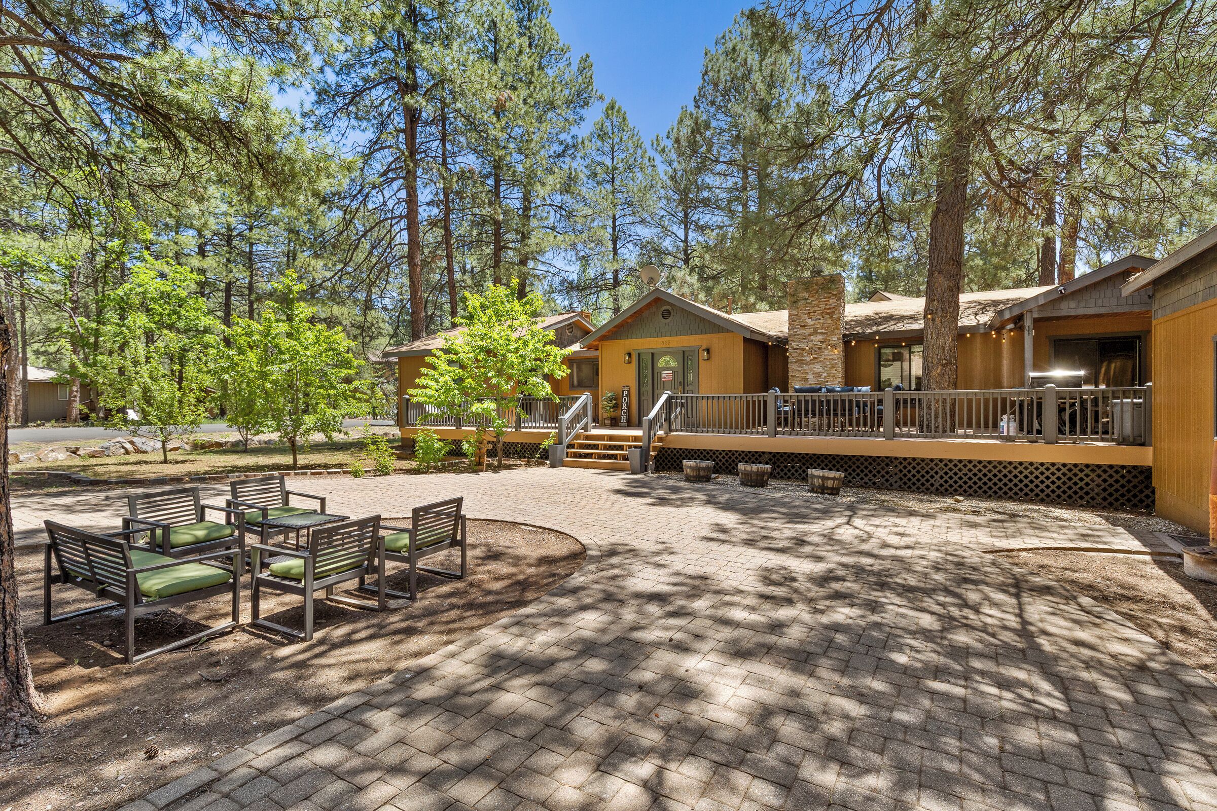 A lodge with outdoor seating, a covered deck, and a stone facade.