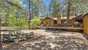 A lodge with outdoor seating, a covered deck, and a stone facade.