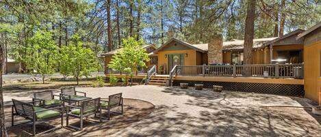 A lodge with outdoor seating, a covered deck, and a stone facade.