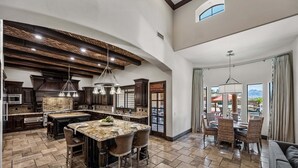 A spacious kitchen with a large island, dark wood cabinetry, and a vaulted ceiling. - 104th Mesa 1331 Paradise Found (Mesa)