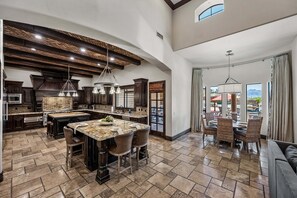 A spacious kitchen with a large island, dark wood cabinetry, and a vaulted ceiling. - 104th Mesa 1331 Paradise Found (Mesa)
