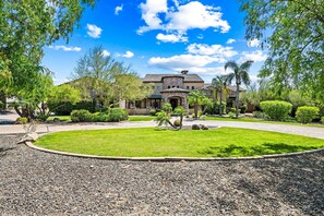 A large house with a well-maintained lawn, a driveway, and surrounding trees. - 104th Mesa 1331 Paradise Found (Mesa)