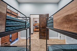 A dormitory room with bunk beds, a wooden door, and a carpeted floor. - 104th Mesa 1331 Paradise Found (Mesa)