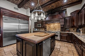 A spacious kitchen with a large island, stainless steel appliances, and dark wood cabinetry. - 104th Mesa 1331 Paradise Found (Mesa)