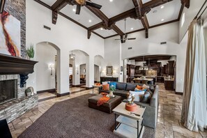 A spacious living room with a fireplace, a large sofa, a coffee table, and an archway leading to another room. - 104th Mesa 1331 Paradise Found (Mesa)
