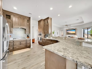 A modern kitchen with wooden cabinets, granite countertops, and stainless steel appliances. - Golden Eagle Fountain Hills (Fountain Hills)
