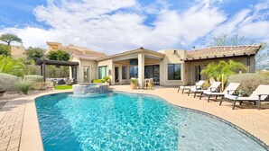Una propiedad residencial con piscina, zona de estar exterior y patio.